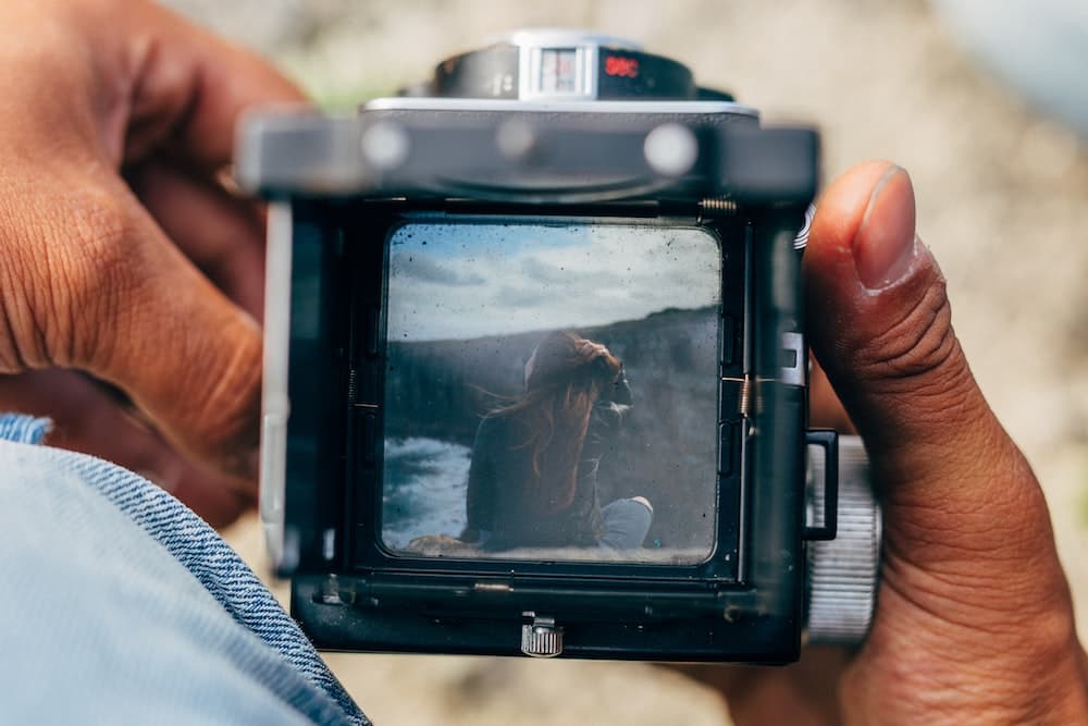 pessoa segurando câmera dslr preta
