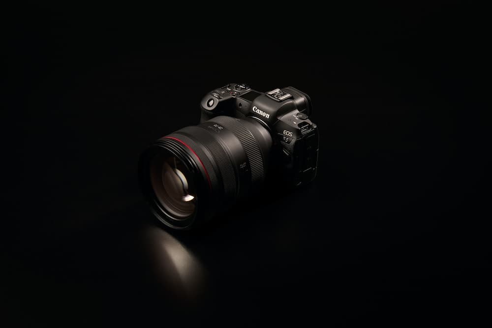 câmera preta nikon dslr na superfície preta